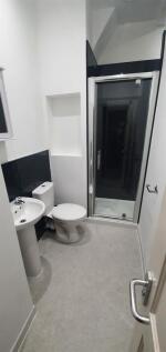 Bright, modern bathroom featuring a corner show...