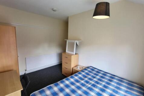 Bright, simply furnished bedroom with a double ...