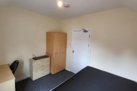 Bright, simply furnished bedroom with a double ...