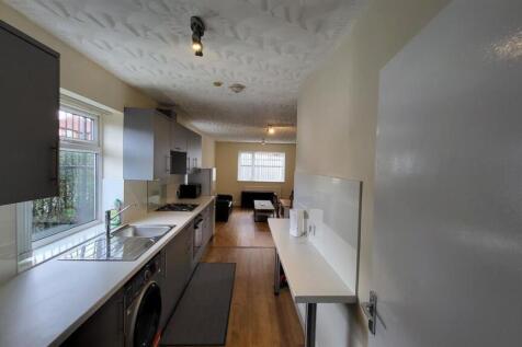 Bright galley-style kitchen with long worktops,...