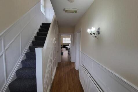 Bright, neatly maintained hallway with wood-eff...