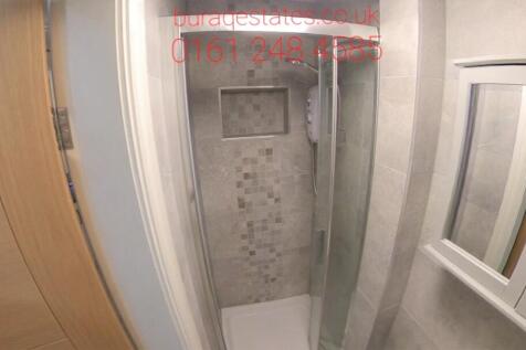 Modern shower cubicle with patterned tile accen...