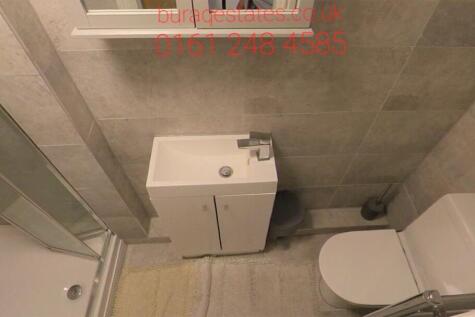 Modern tiled bathroom with a corner shower, com...