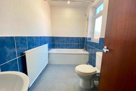 Bright, tidy bathroom featuring a bath with sho...