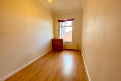 Bright, narrow bedroom with wood-effect floorin...