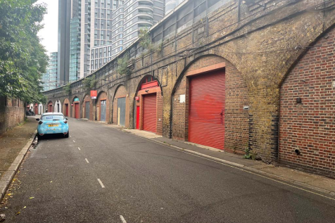 An estate, with multiple arches next to each other. The arches have closed electric roller shutter entrances.