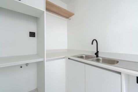 Separate scullery with double sink, storage space and door opening onto the back of the house