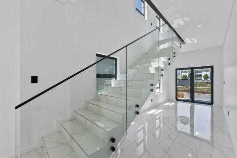 Double entrance doors and modern staircase leading up to three ensuite bedrooms