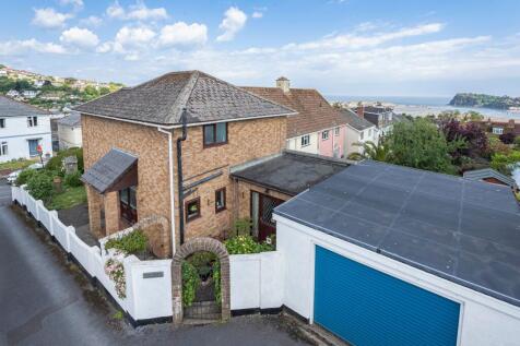 Rear of property with sea views beyond and garage