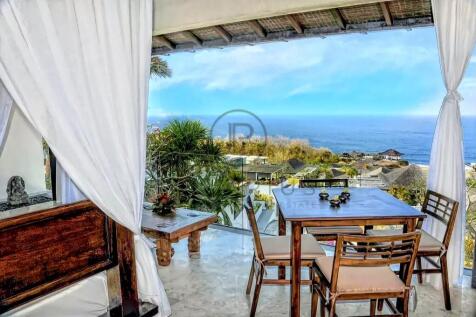 A tropical open-air dining area with wooden furnit