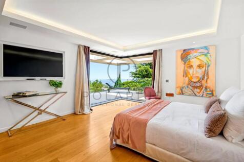 A spacious, modern bedroom with a large bed, artwo