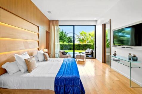 Modern bedroom with wooden flooring, a stylish bed