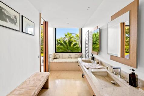 Modern bathroom with dual sinks, a large mirror, a