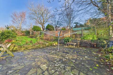 Spacious Garden with a mixture of lawn, mature shrubs, fruit trees and flagstone seating area.