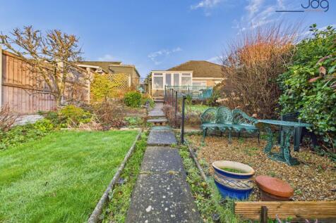 A generous, tiered rear garden with paved seating areas and lawn