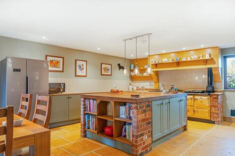 Solid oak worktops and exposed brick add character to this kitchen