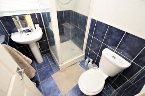 Modern bathroom featuring a compact shower unit...
