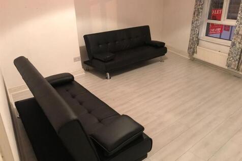Bright living room with sleek black sofas...