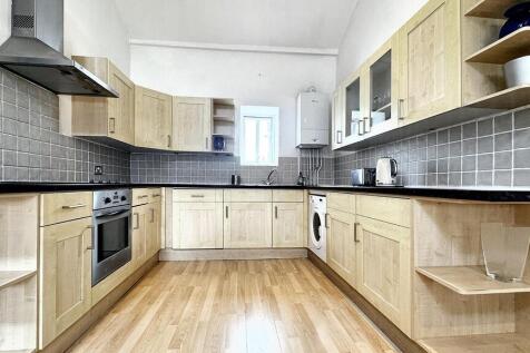 Spacious kitchen with modern wood-style cabinet...