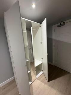 Bright, modern hallway with light wood flooring...