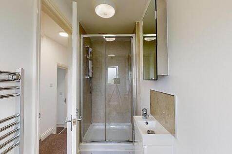 Bright, modern bathroom with a glass-enclosed s...