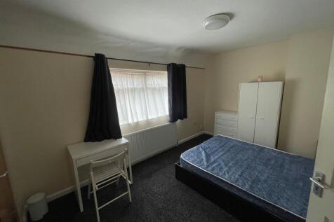 Bright, simply furnished bedroom with a double ...