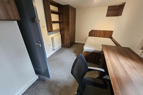 A neat and functional student bedroom featuring...