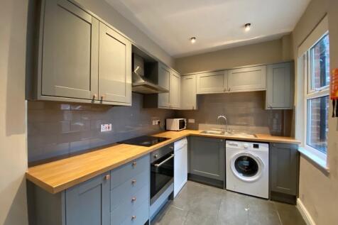 Modern fitted kitchen with grey shaker cabinets...
