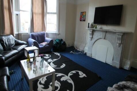 A spacious and bright living room featuring com...