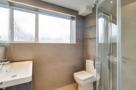 Modern bathroom with stylish tiles and glass sh...