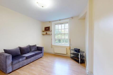 Bright lounge with plush sofa and wood floors...