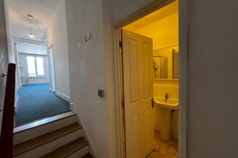 Bright hallway leads to a clean modern bathroom...