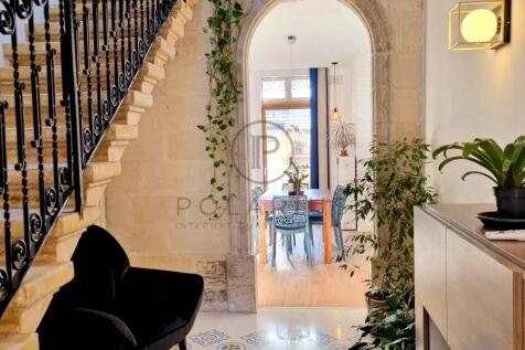 A stylish hallway with a black chair and patterned