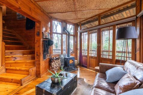 Rear kitchen entrance foyer with hearth, riding gear and stairs toward main bedroom upstairs