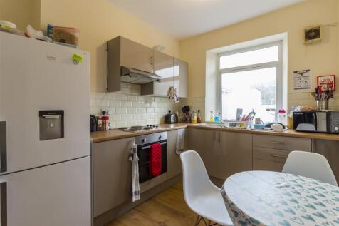 Bright kitchen with modern units and dining are...