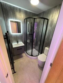 Modern bathroom with a curved glass shower encl...