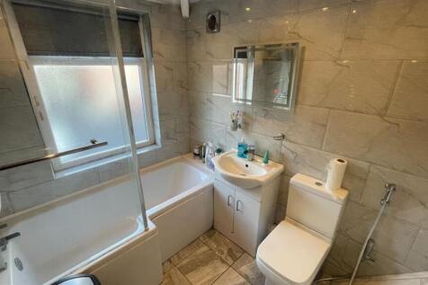 Bright, modern bathroom with tiled walls and fl...