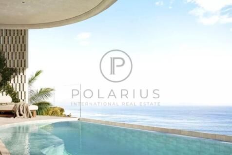 A luxurious infinity pool overlooks a vast ocean v