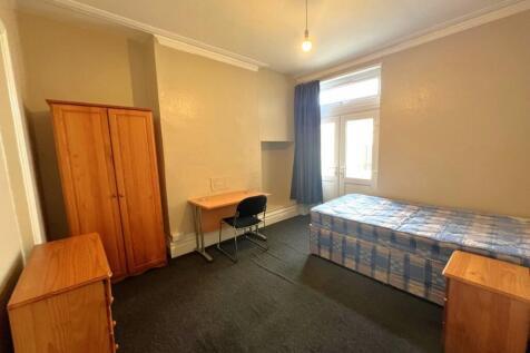 Bright, simply furnished single bedroom with a ...
