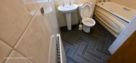 Bright, tidy bathroom with a bathtub, pedestal ...