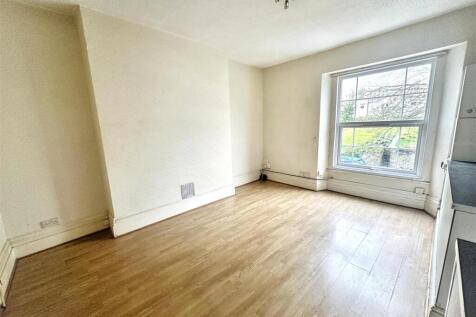 Bright living area with large window, wood floo...