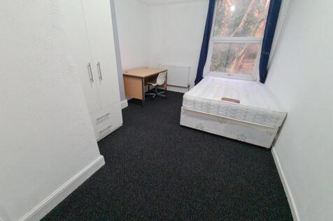 A small, tidy space with a basic toilet setup, ...