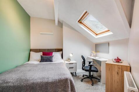 Bright attic bedroom with study desk and skylig...