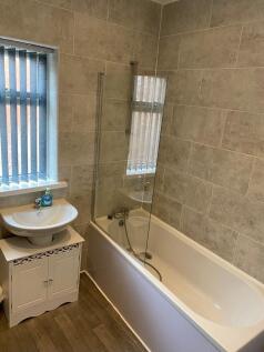 Modern bathroom with full tub and stylish tilin...