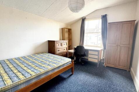 Bright double bedroom with a wooden bed frame, ...