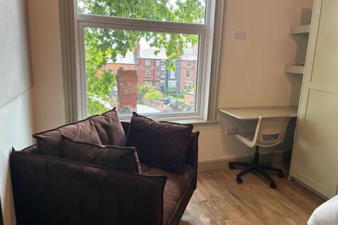 Bright bedroom with large window and study desk...