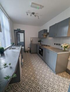 Bright, modern galley kitchen with patterned ti...