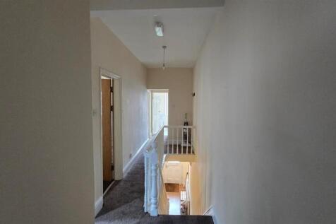 Bright and tidy upper hallway with staircase...