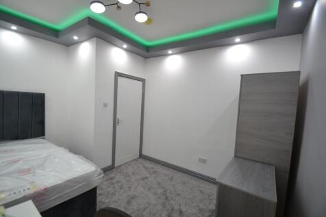 A modern bedroom with crisp white walls, a styl...