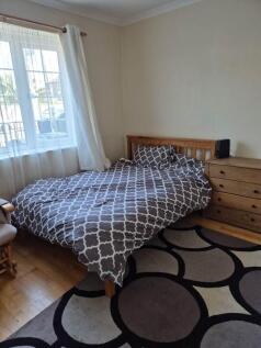 Bright bedroom with large window and double bed...